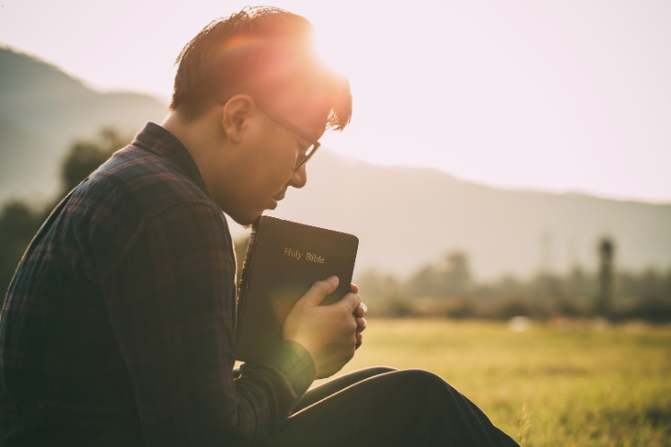 man holding holly bible book in hands